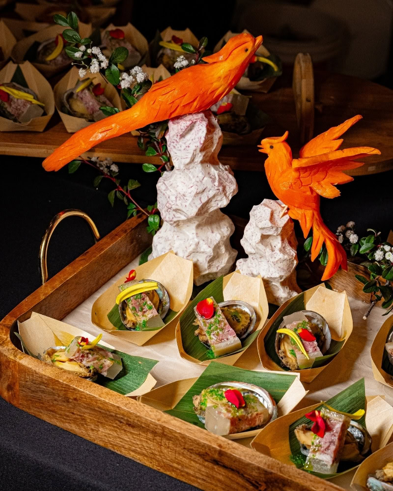 Decorative display with carved carrots and traditional dishes at Chinese Restaurant Awards.