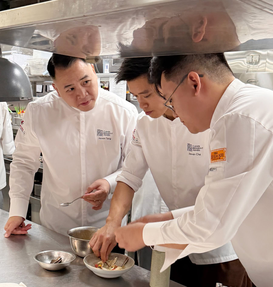 Chinese Chefs at Work in a Kitchen Three Chinese chefs preparing dishes in a professional kitchen environment.