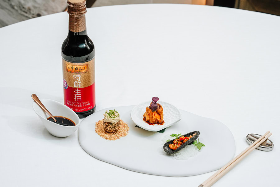 Elegant Chinese Cuisine Presentation Assorted Chinese dishes with soy sauce and condiments on a white table.