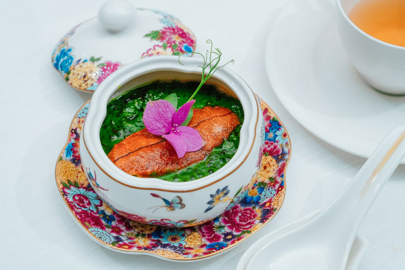 Elegant Chinese Soup with Garnish Traditional Chinese soup served in a floral porcelain bowl with garnish.